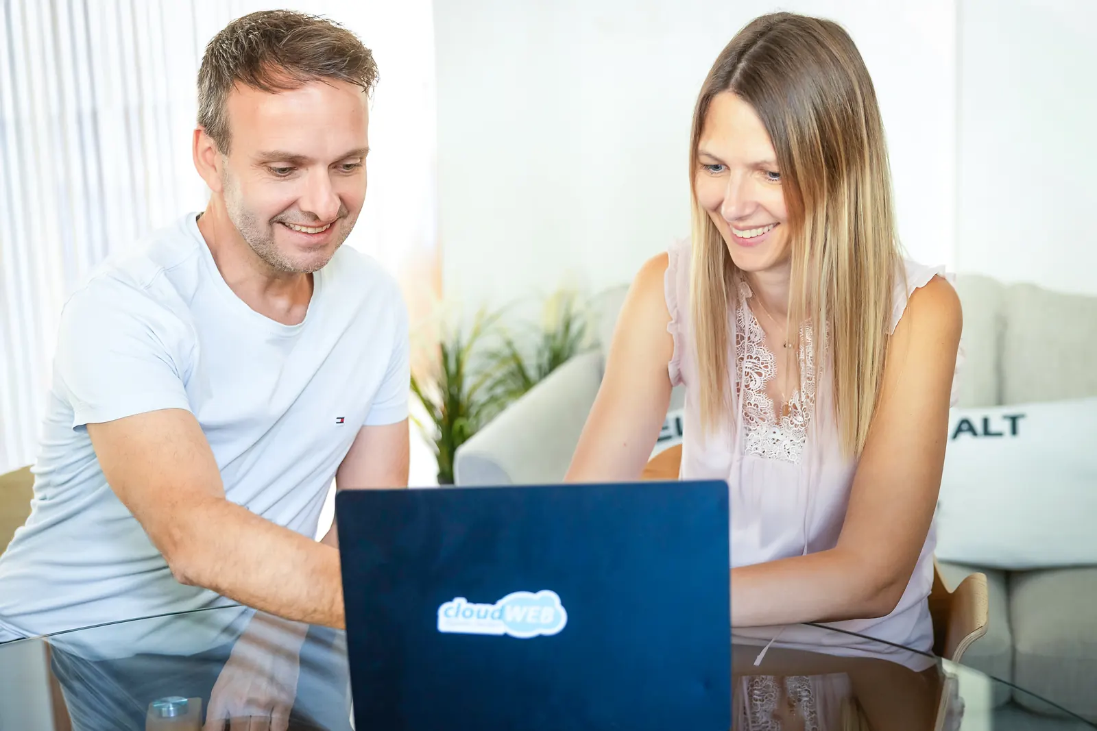 Thomas Hasenfratz, Inhaber, und Martina Bernet, Inhaberin von cloudWEB, gemeinsam am Laptop in der Lounge