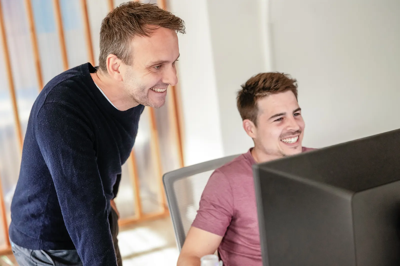 Thomas Hasenfratz, Inhaber von cloudWEB, schaut mit Roman, Paid Search, auf dessen Bildschirm